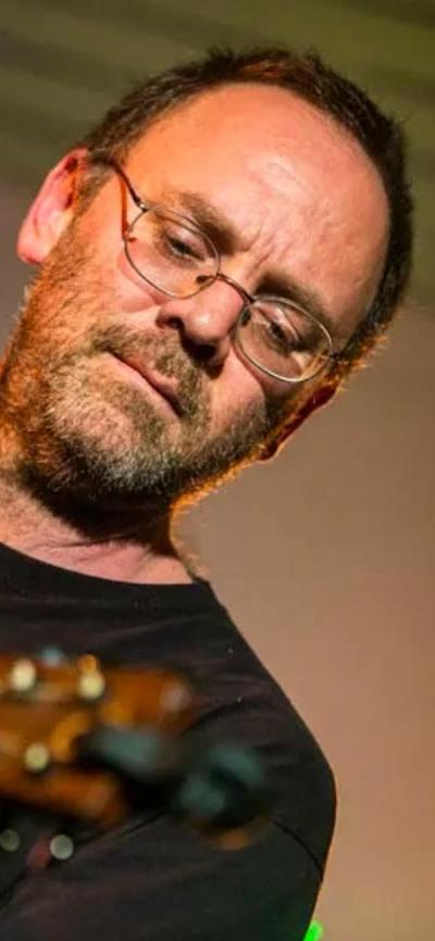 David Rovics playing a guitar in front of a microphone