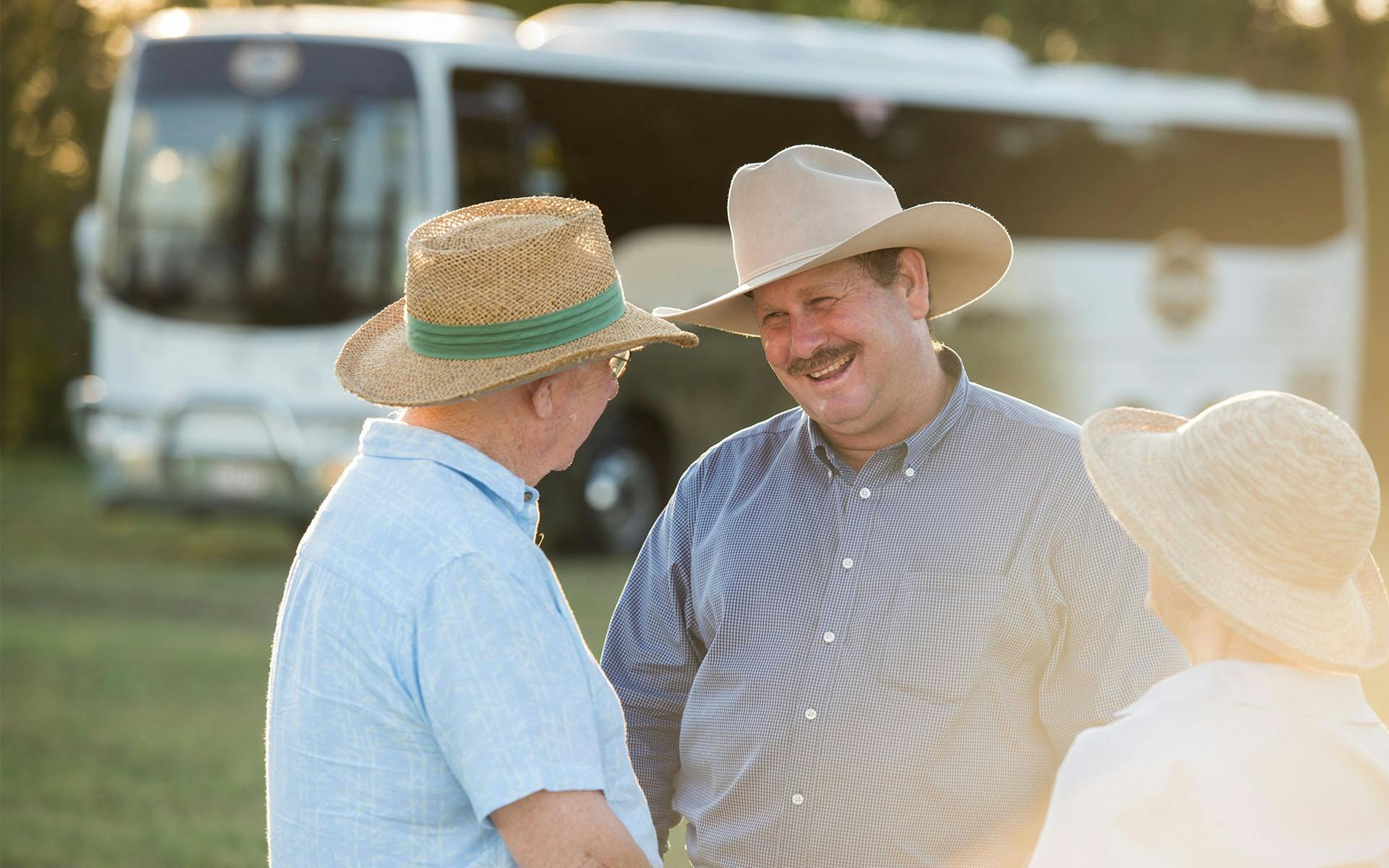 Richard Kinnon smiling and chatting with elderly man and woman