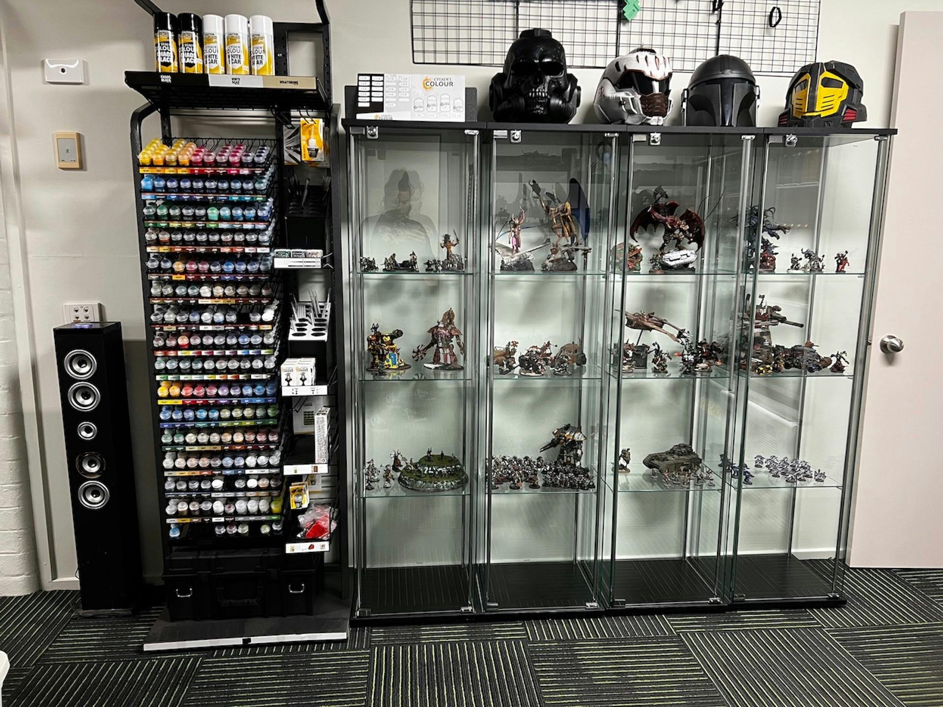 Paints and glass cabinets displaying painted miniatures and collectible helmets.