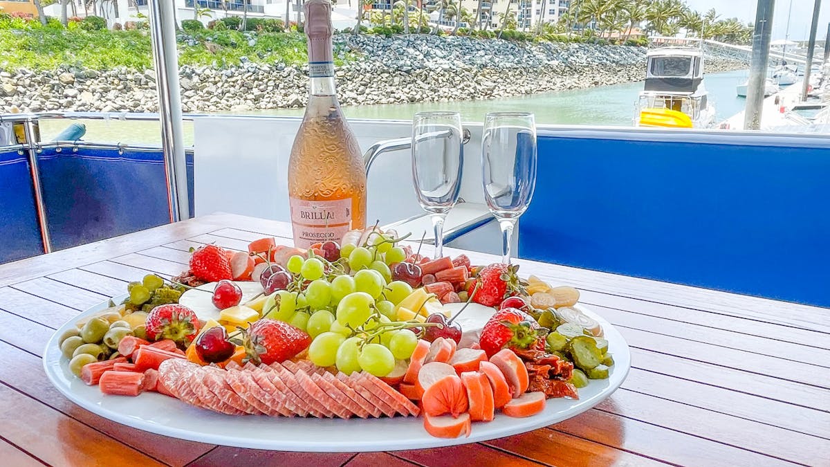 Antipasto platter on top deck table with cold wine and glasses