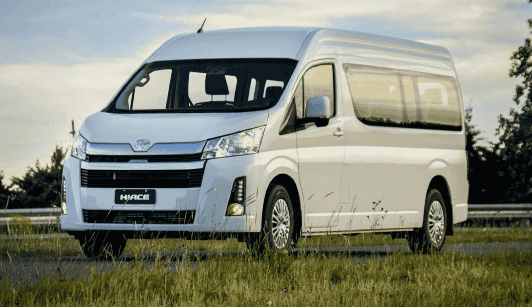 White Hiace 11 seater bus parked on green grass