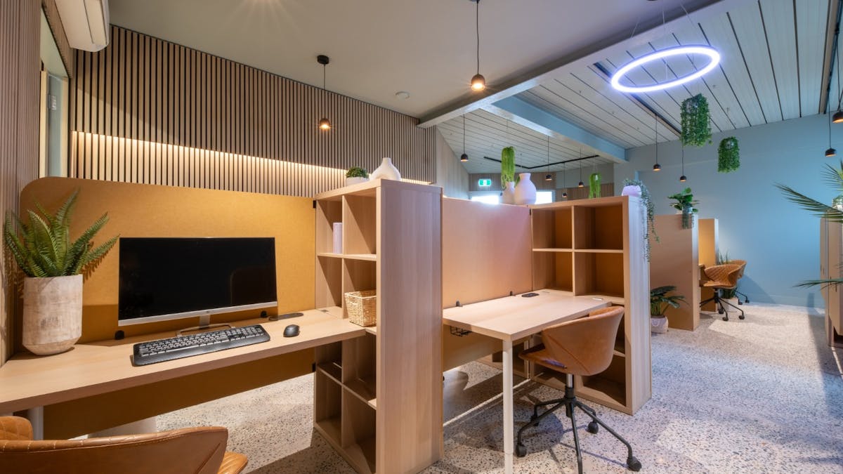 A modern hot desk at Beachfront Collaborative with monitor, power and seating.