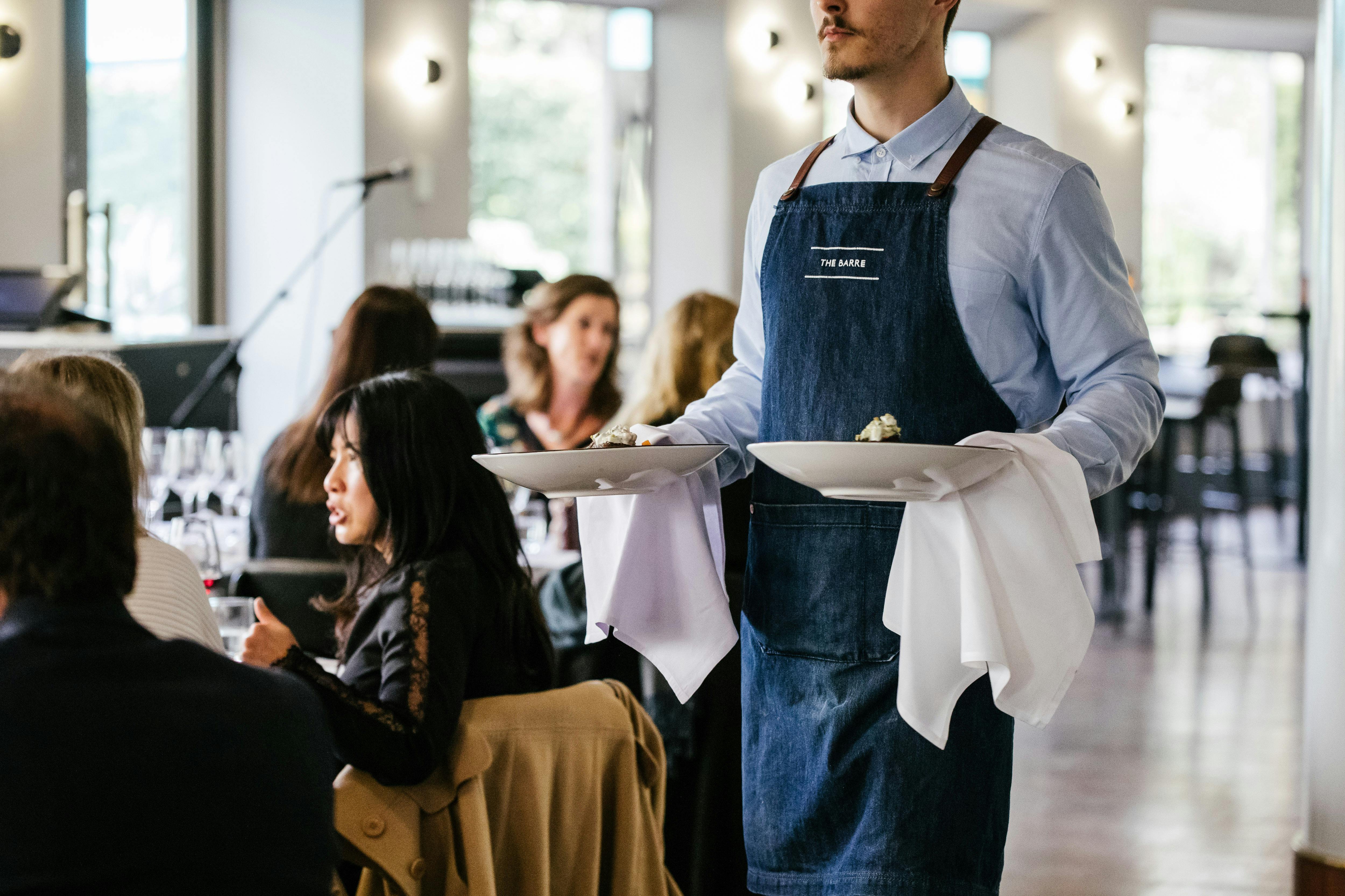 Waiter carrying plates at The Barre