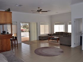 A spacious, open plan family room is equipped with a bar area and ample seating.