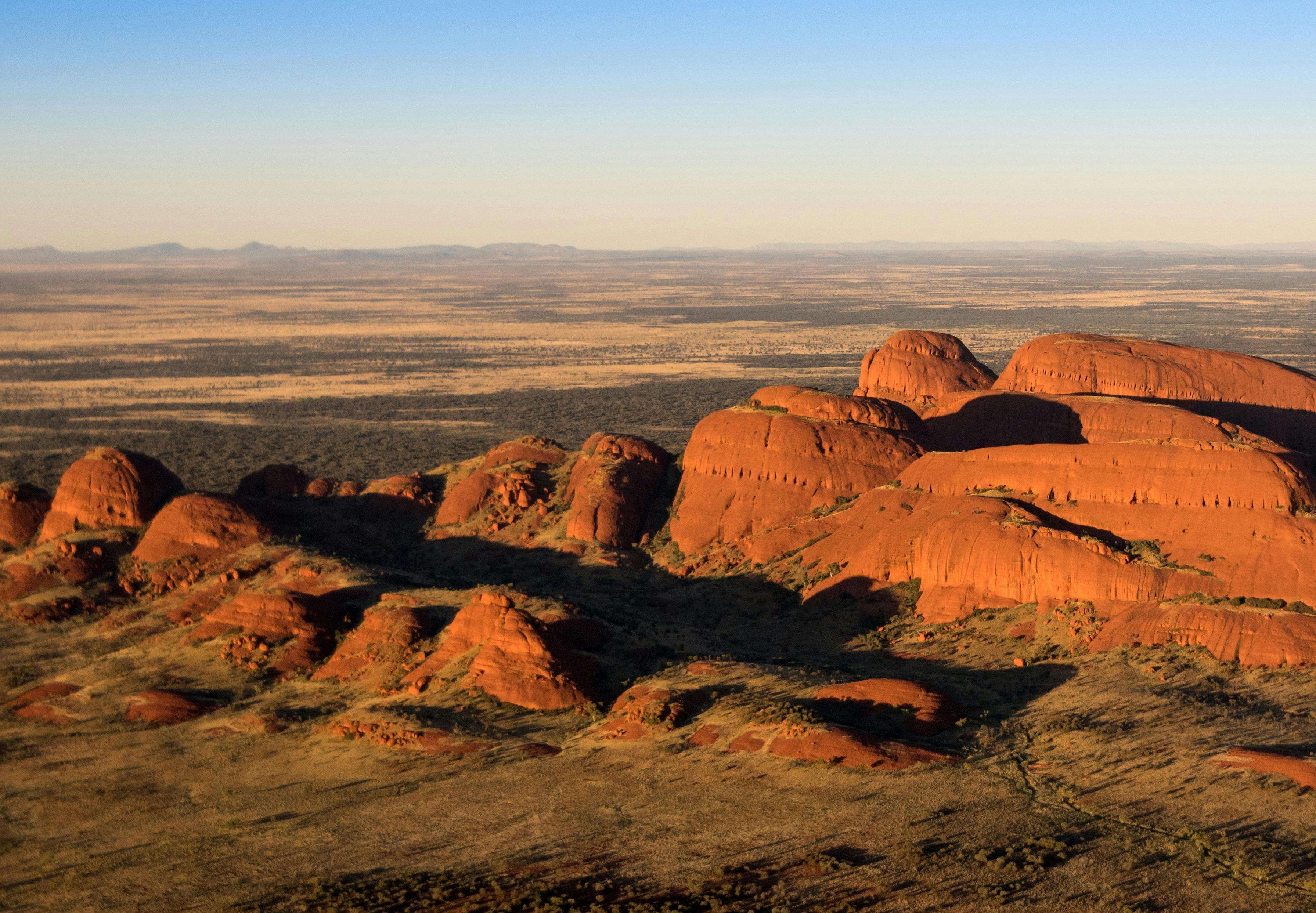 Small and large red rocks on a flat plain