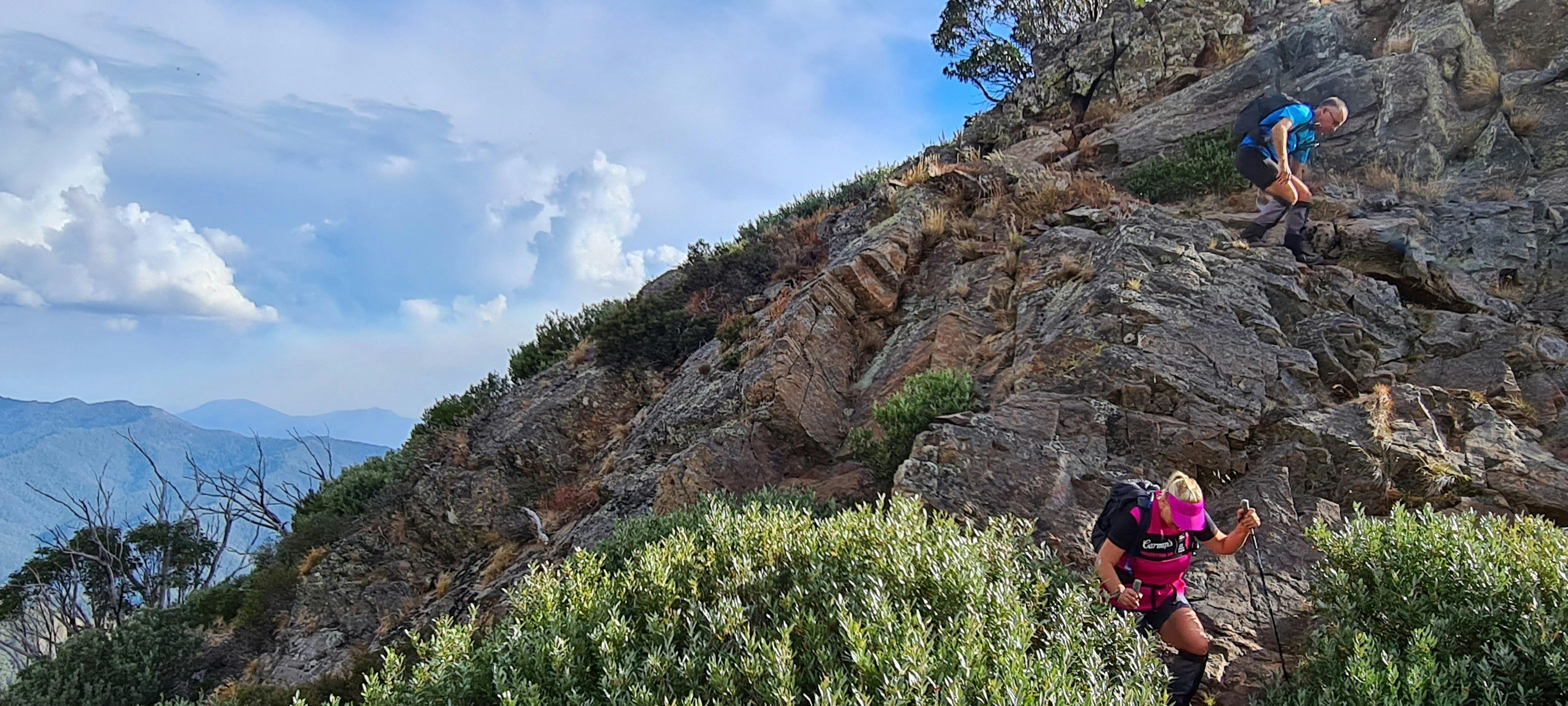 A couple of hikers coming down a rocky section of the trail.
