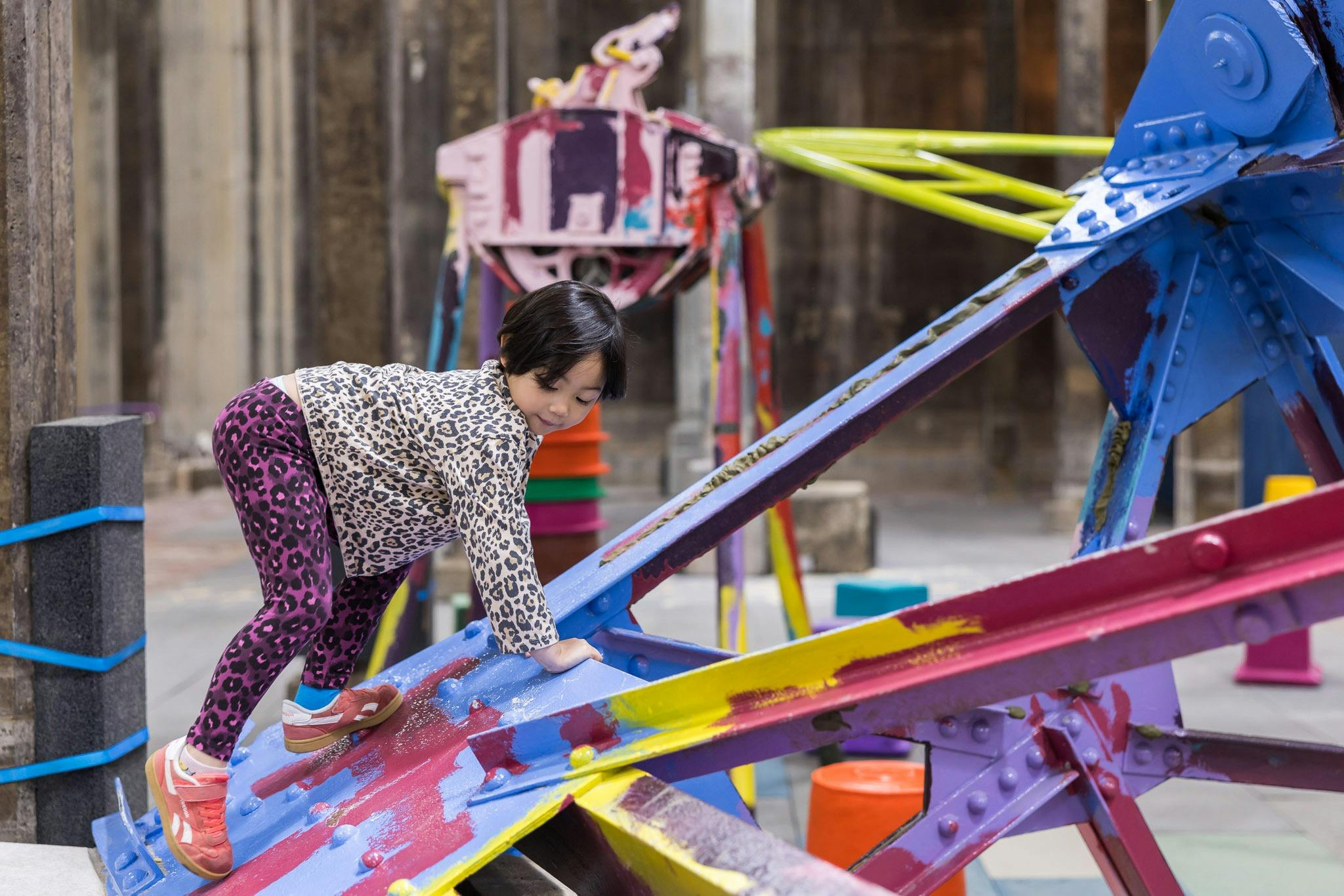 children climbing on play equipment in an underground space in an art gallery