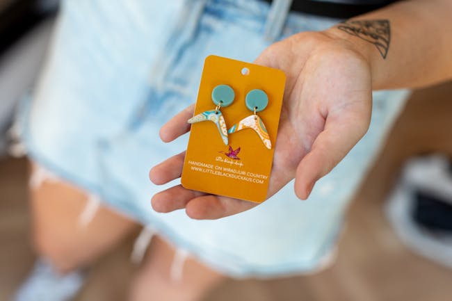 hand holding boomerang earrings