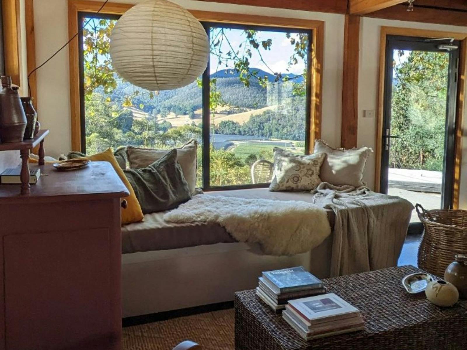 Luxurious daybed drapped with cushions and throws overlooking the deck, spa and valley views