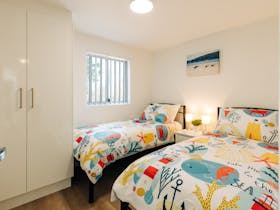 Twin single beds and built in wardrobe in bedroom 5 on lower storey