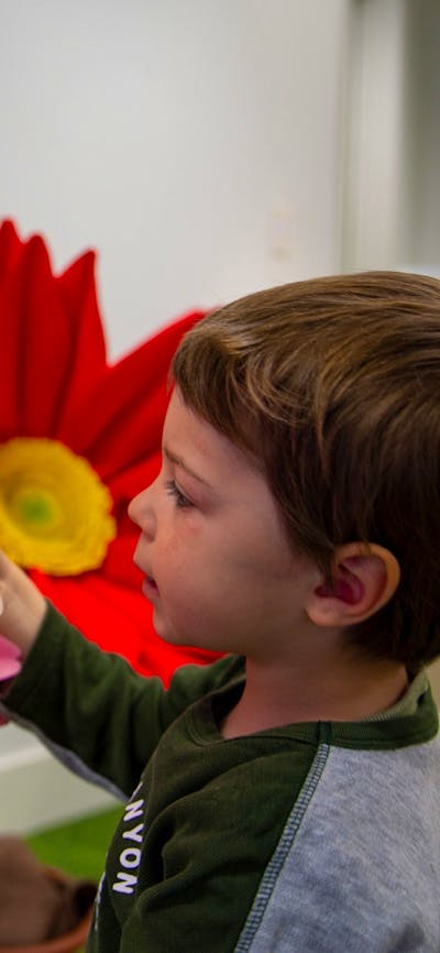 A child explores flowers at Science Time: Spring
