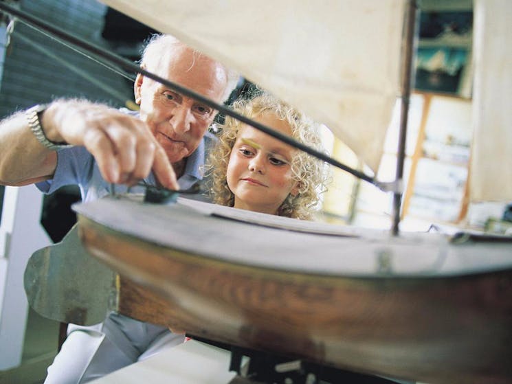 Volunteer showing girl boat model