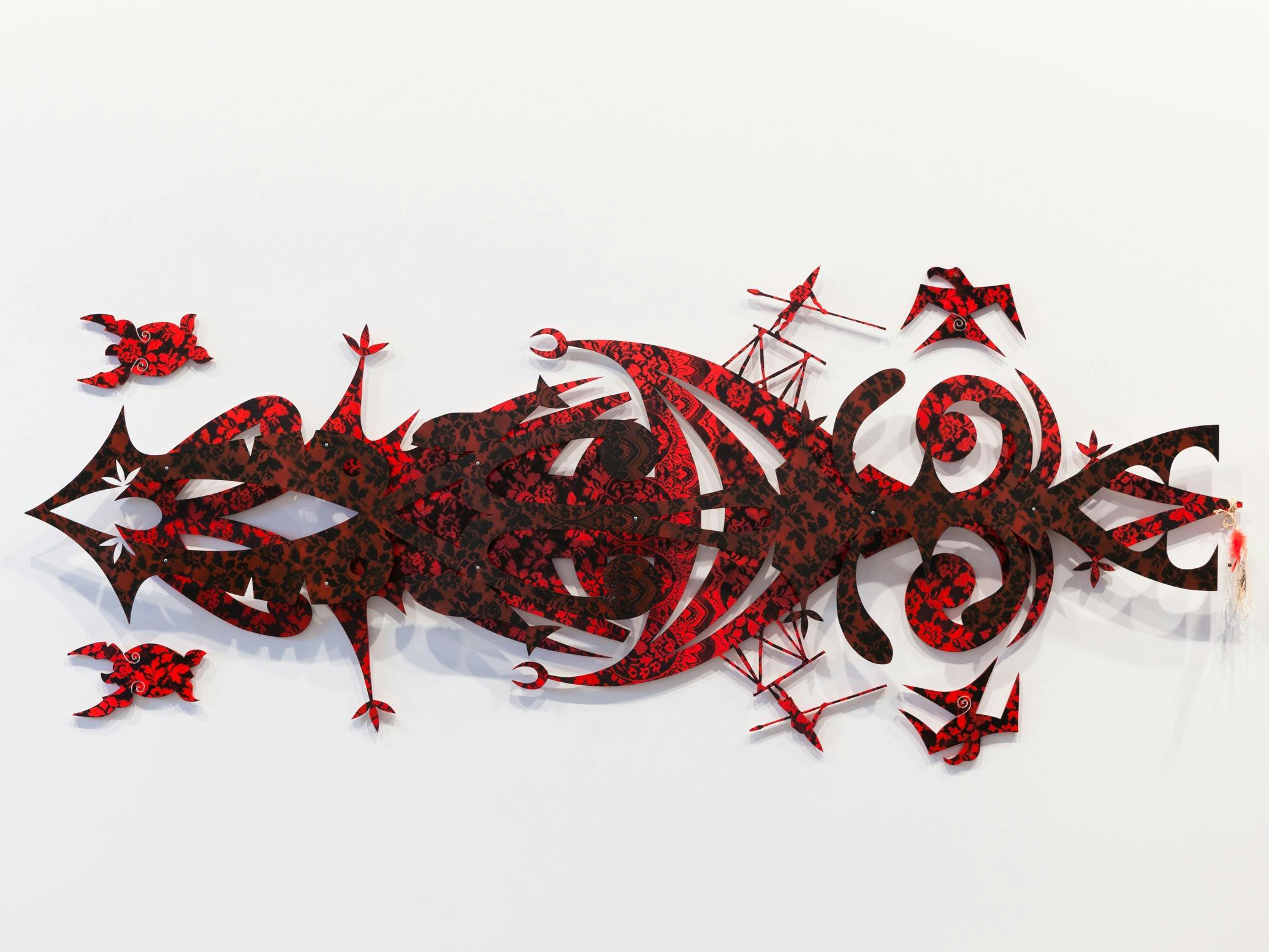 A large red sculptural tapestry
