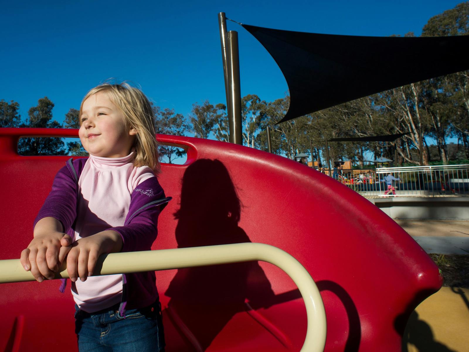 Girl on a spinning piece of play equipment in the Boundless Playground