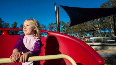 Girl on a spinning piece of play equipment in the Boundless Playground