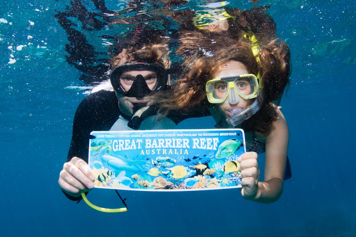 A couple pose for a photo on the Great Barrier Reef with Passions of Paradise