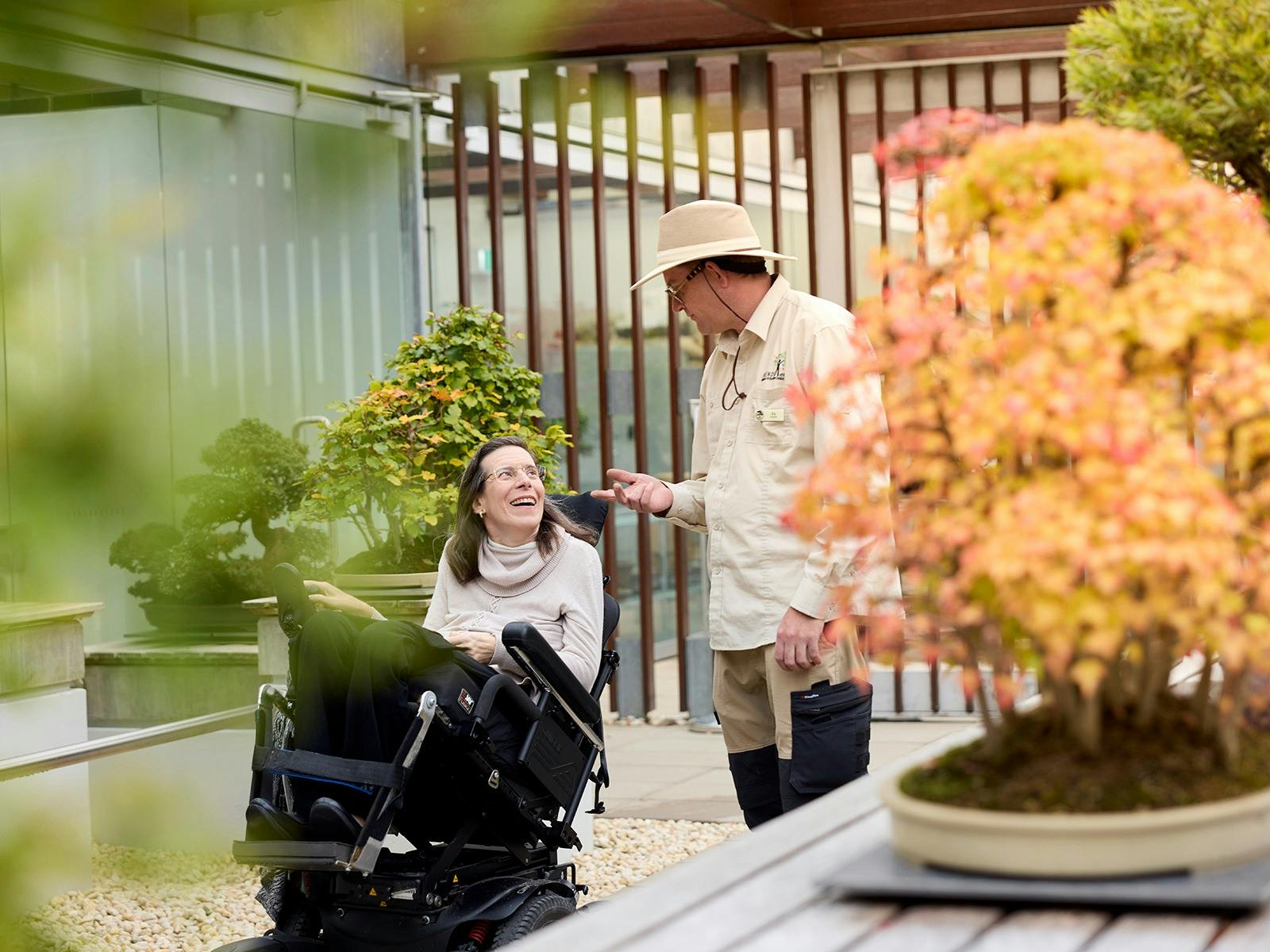 Volunteer guide talking with visitor in a wheelchair