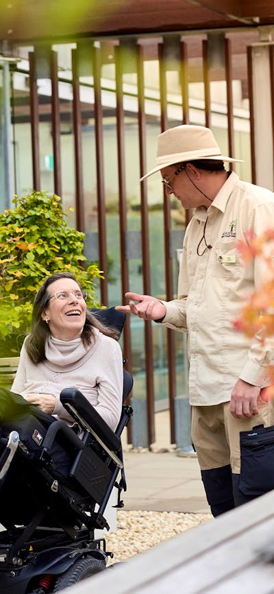 Volunteer guide talking with visitor in a wheelchair