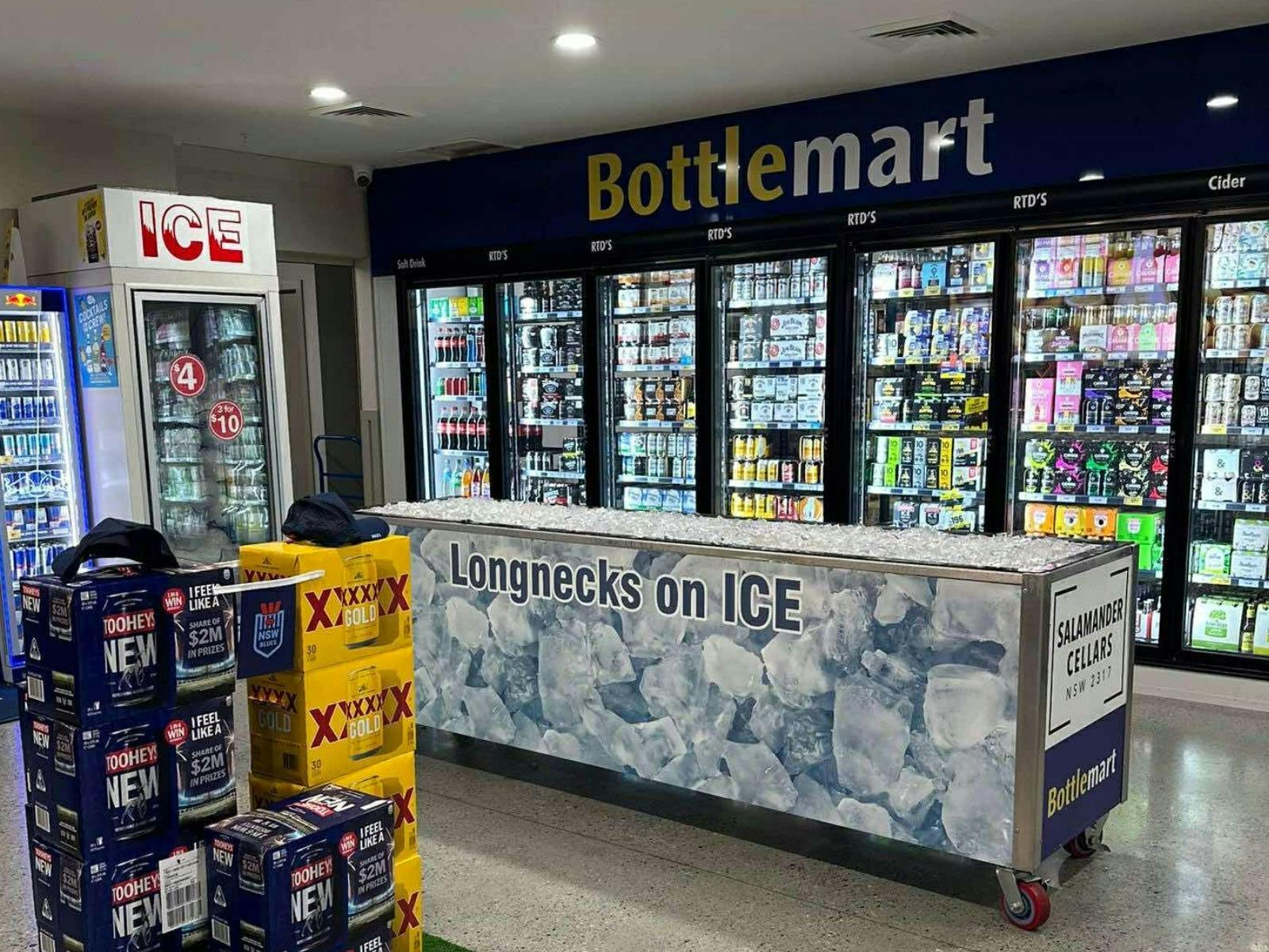 interior of a bottle shop with large fridges on the wall and deep freezer in the centre