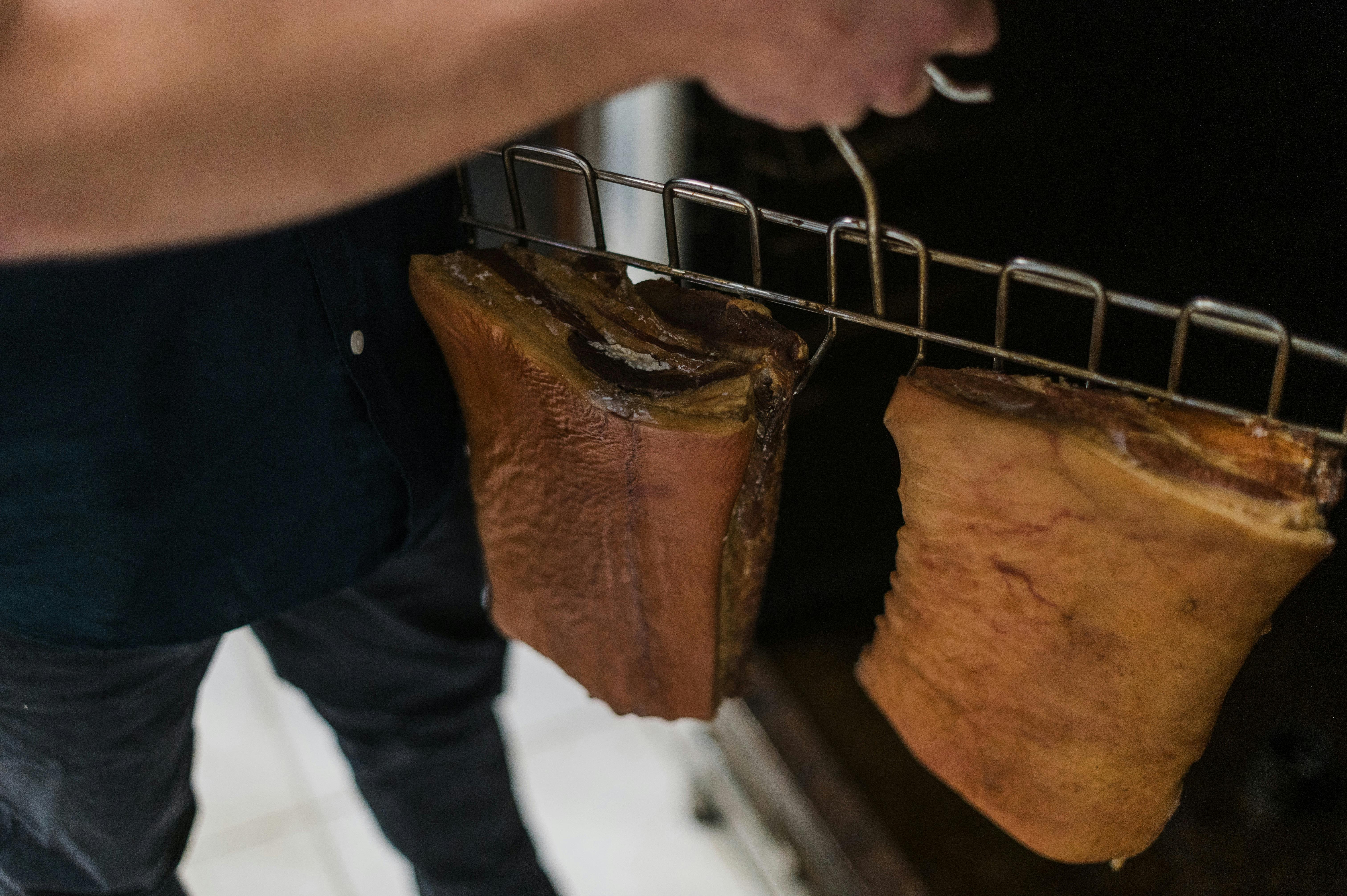 Image shows our staff loading the onsite smoke oven with full bacon bellies