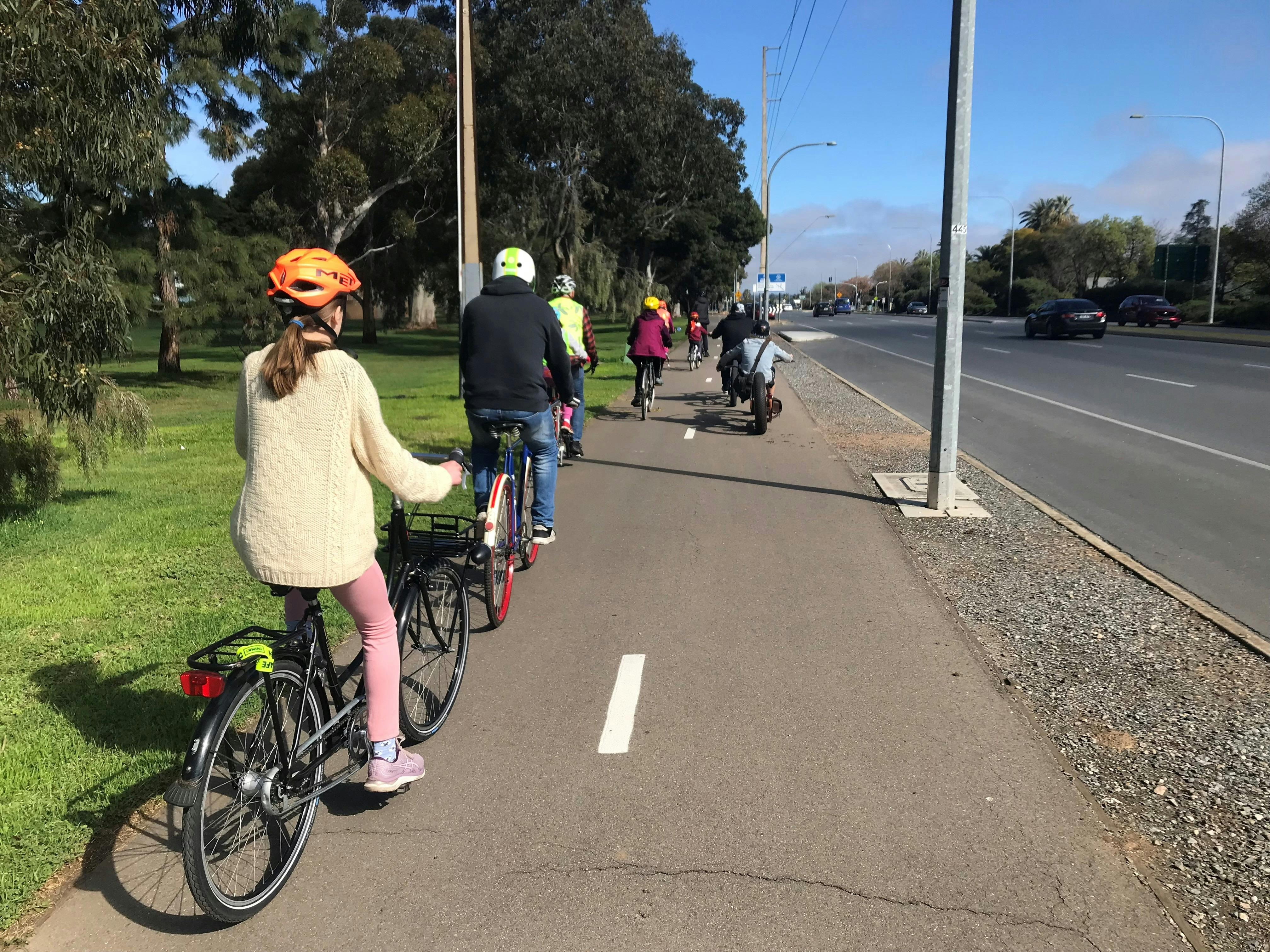A group of people cycling along a shared path through the Park Lands