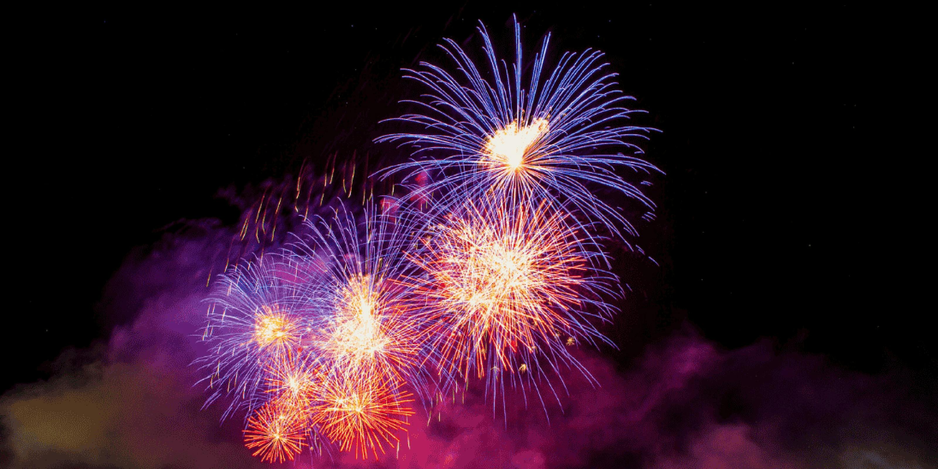 Fireworks bursting with purple and pink colours in in the night sky