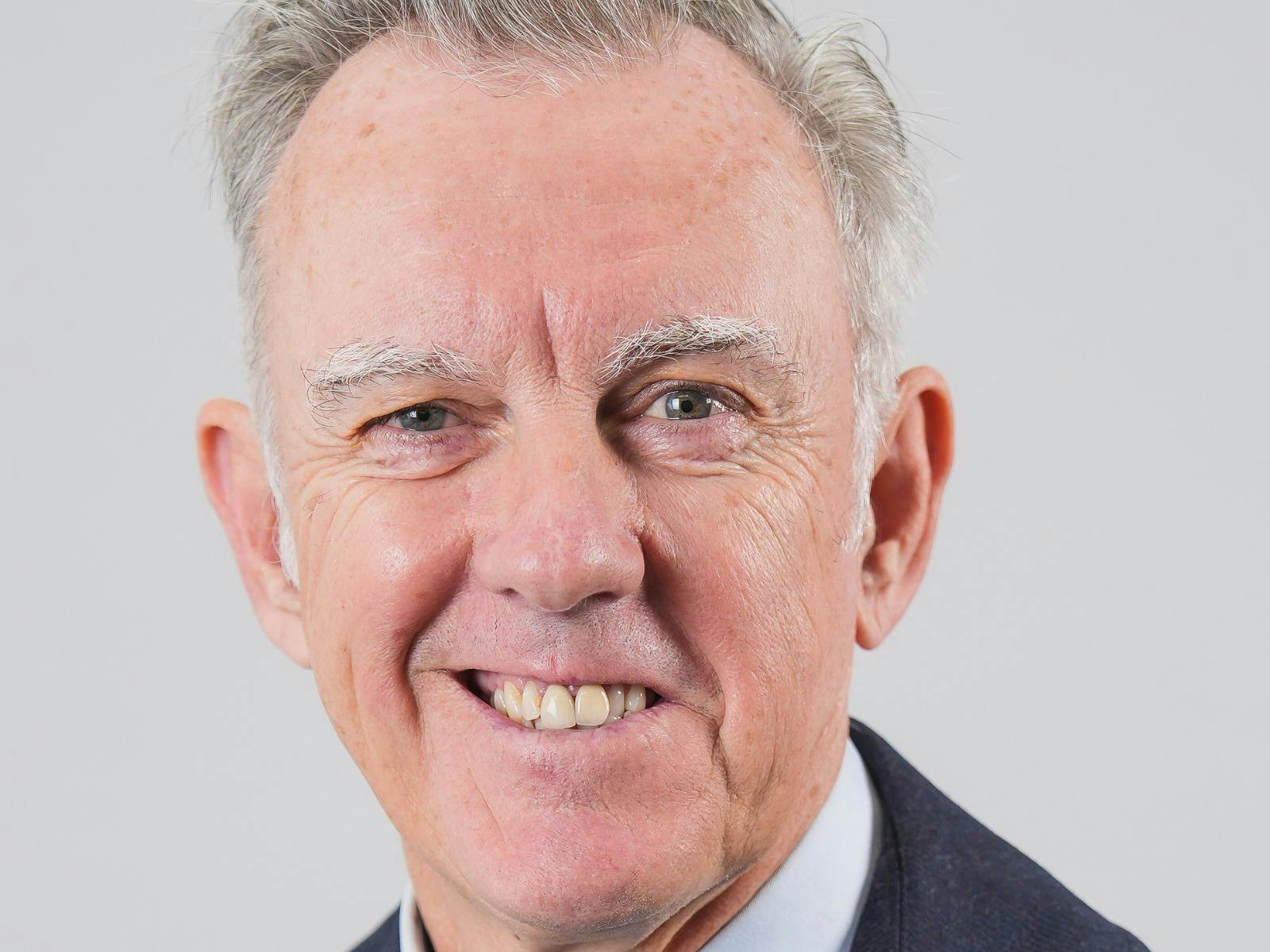 A smiling man with gray hair.
