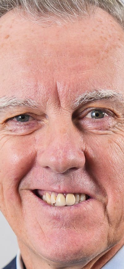 A smiling man with gray hair.