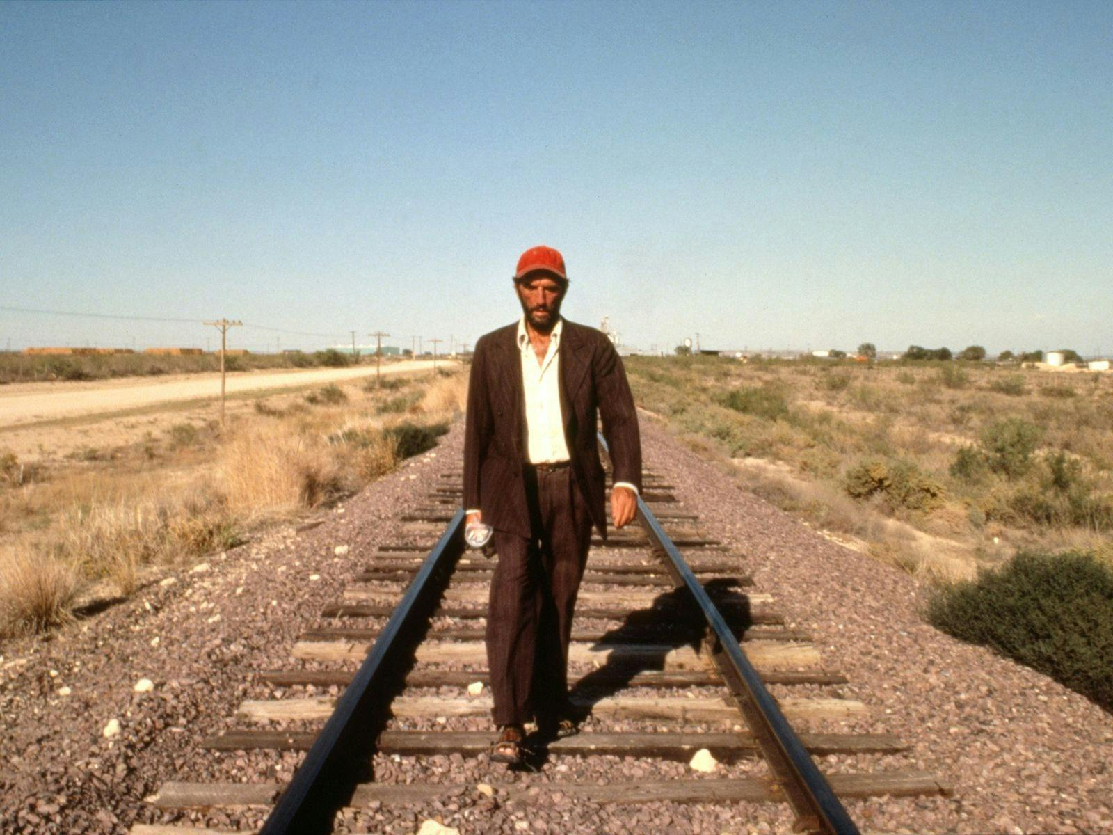 Man walking on train tracks in rural America