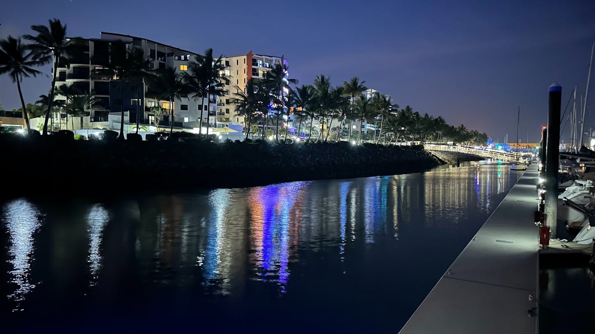 image of colourful lights on marina apartments reflecting on the water