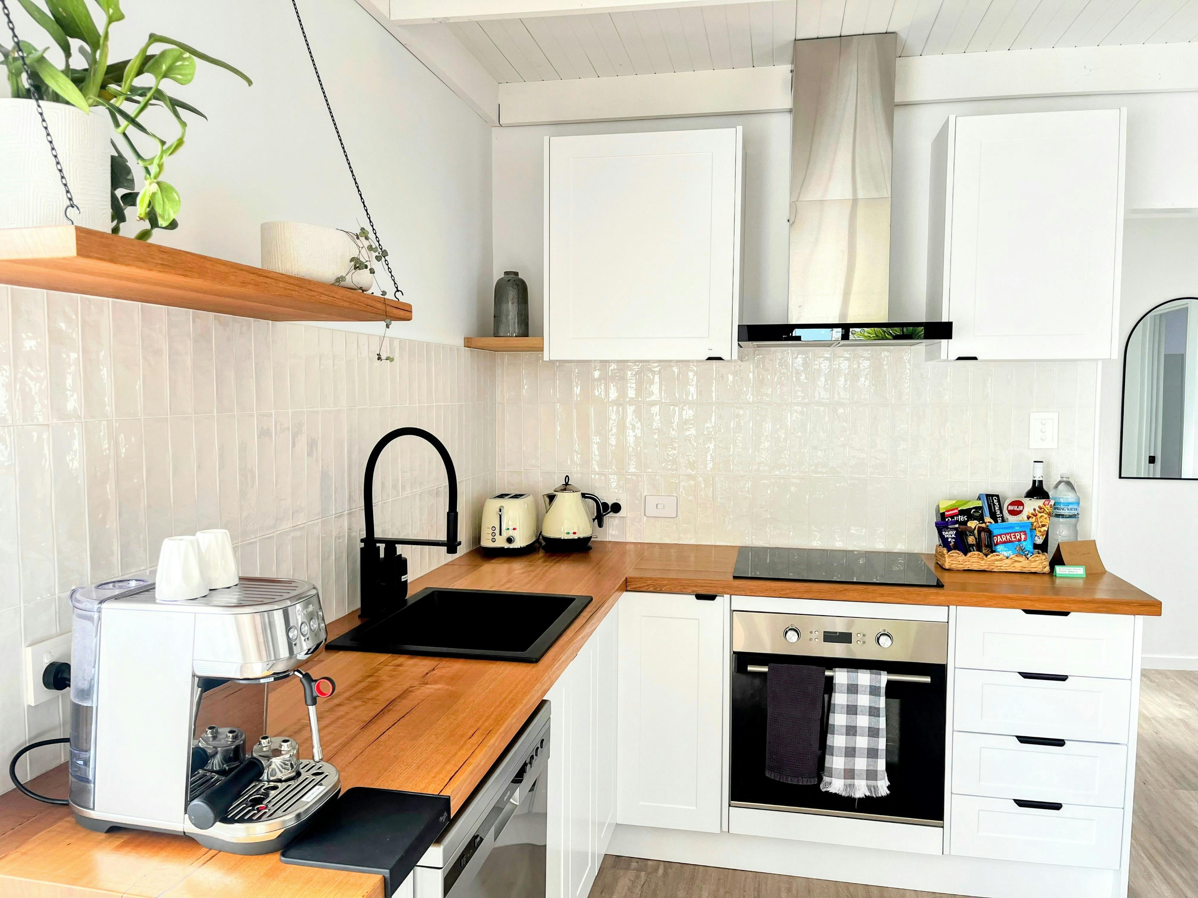 Fully equiped kitchen with stovetop, oven, microwave, full-size fridge and coffee machine