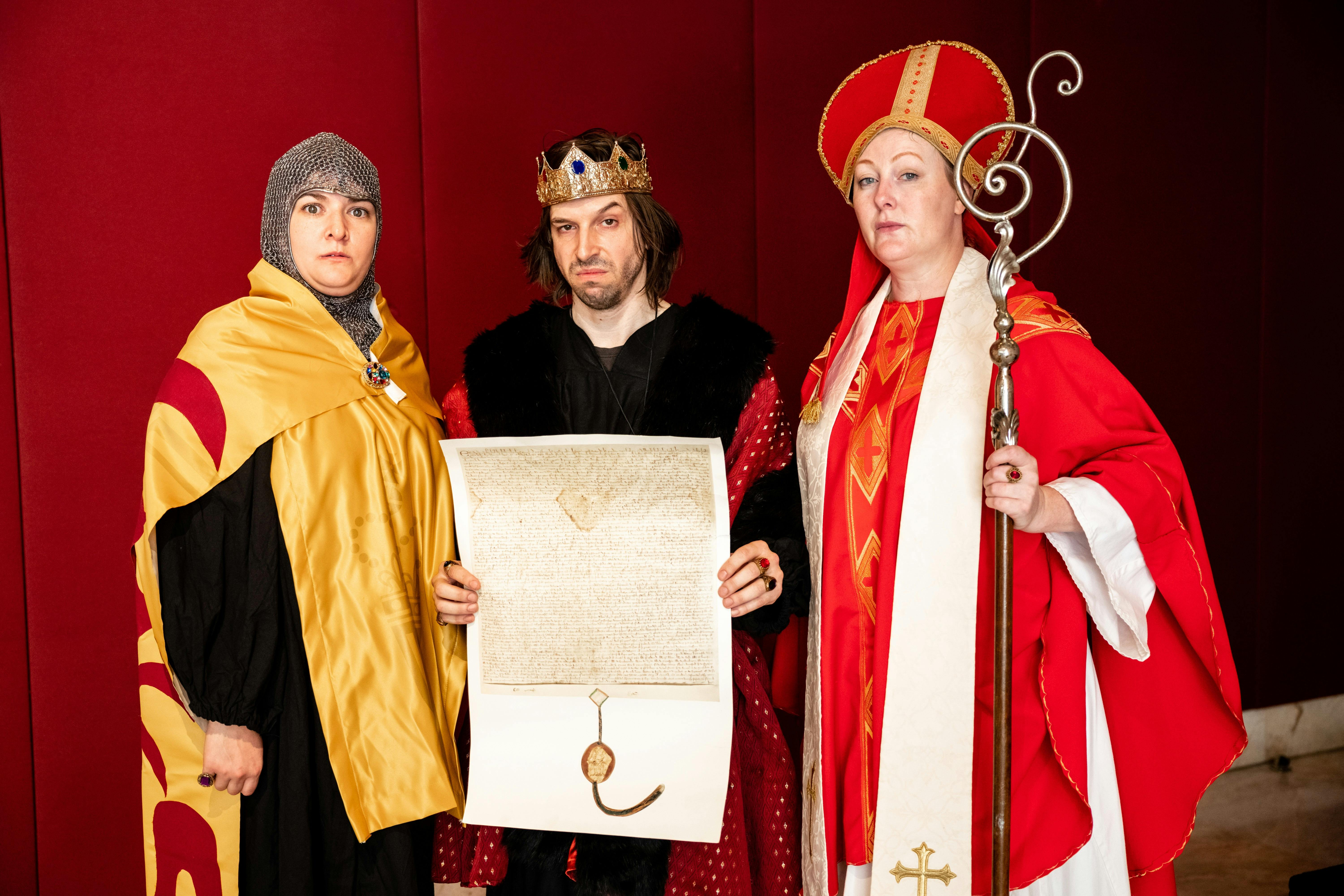 Performers dressed up in historic regal costumes pose at Family Fun Day at Parliament of NSW