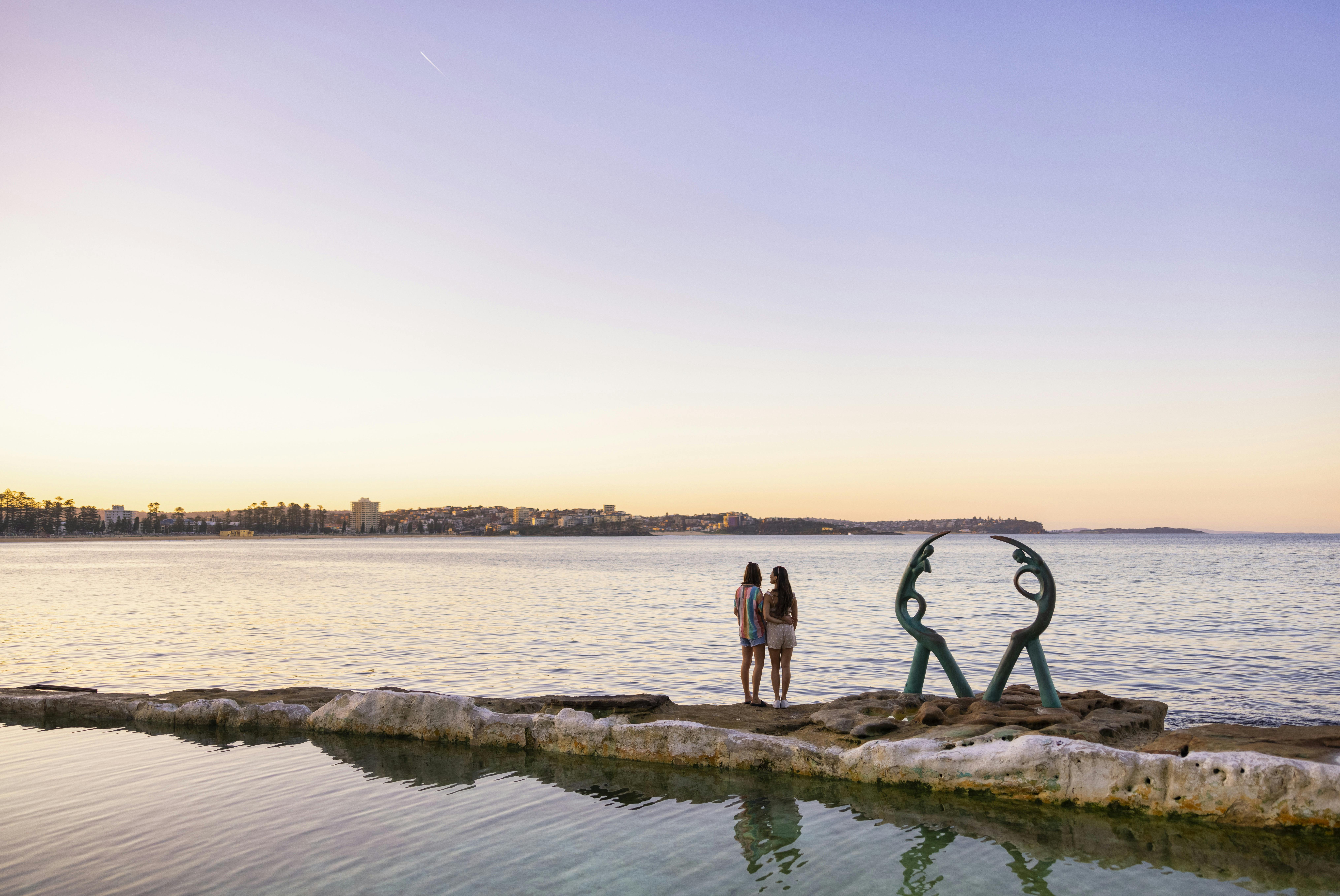 Couple relaxing by the water at Fairy Bower Pool, Manly, Sydney.