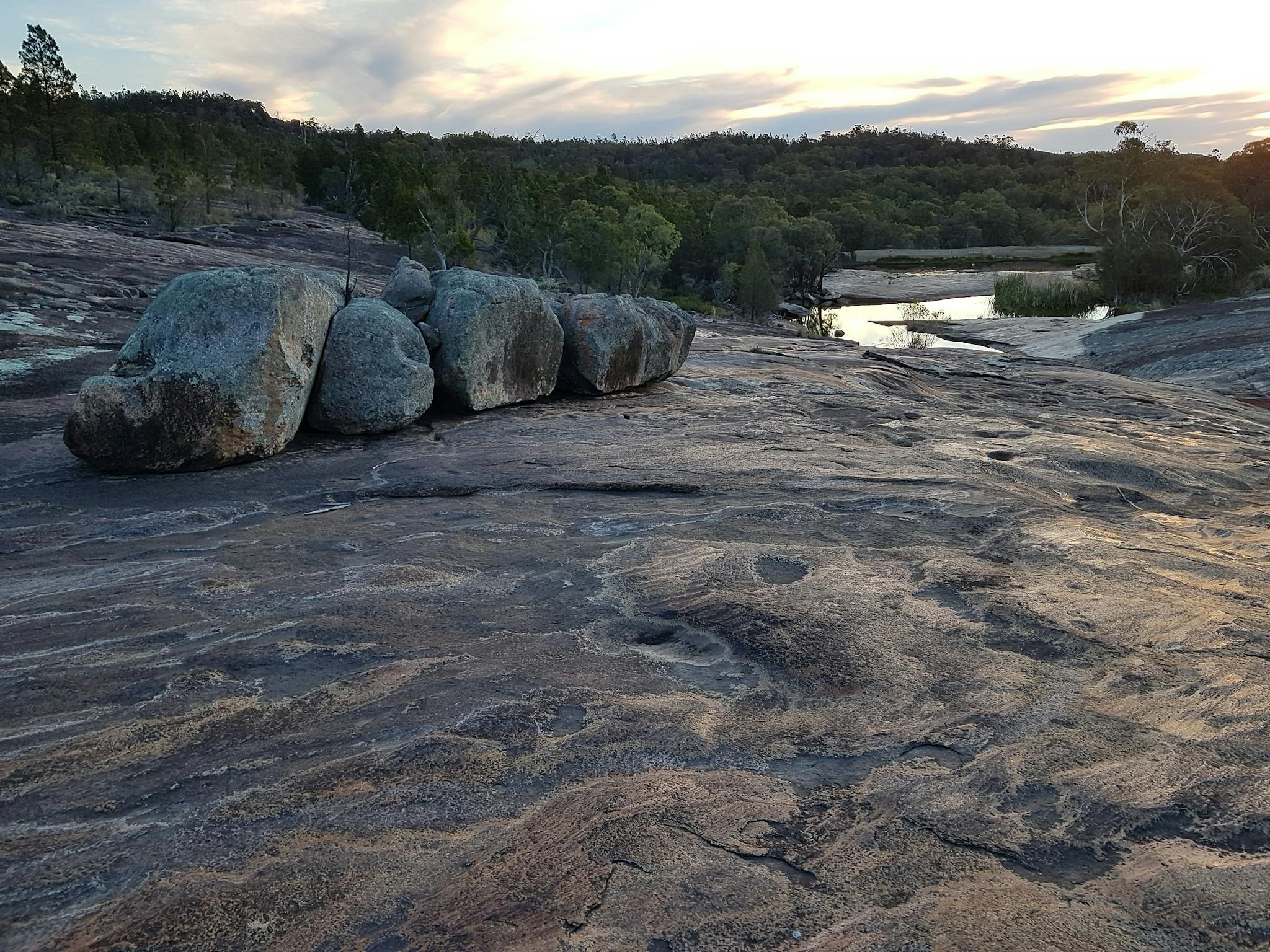 Exposed areas of granite, with large boulders. Water cascades after rain.