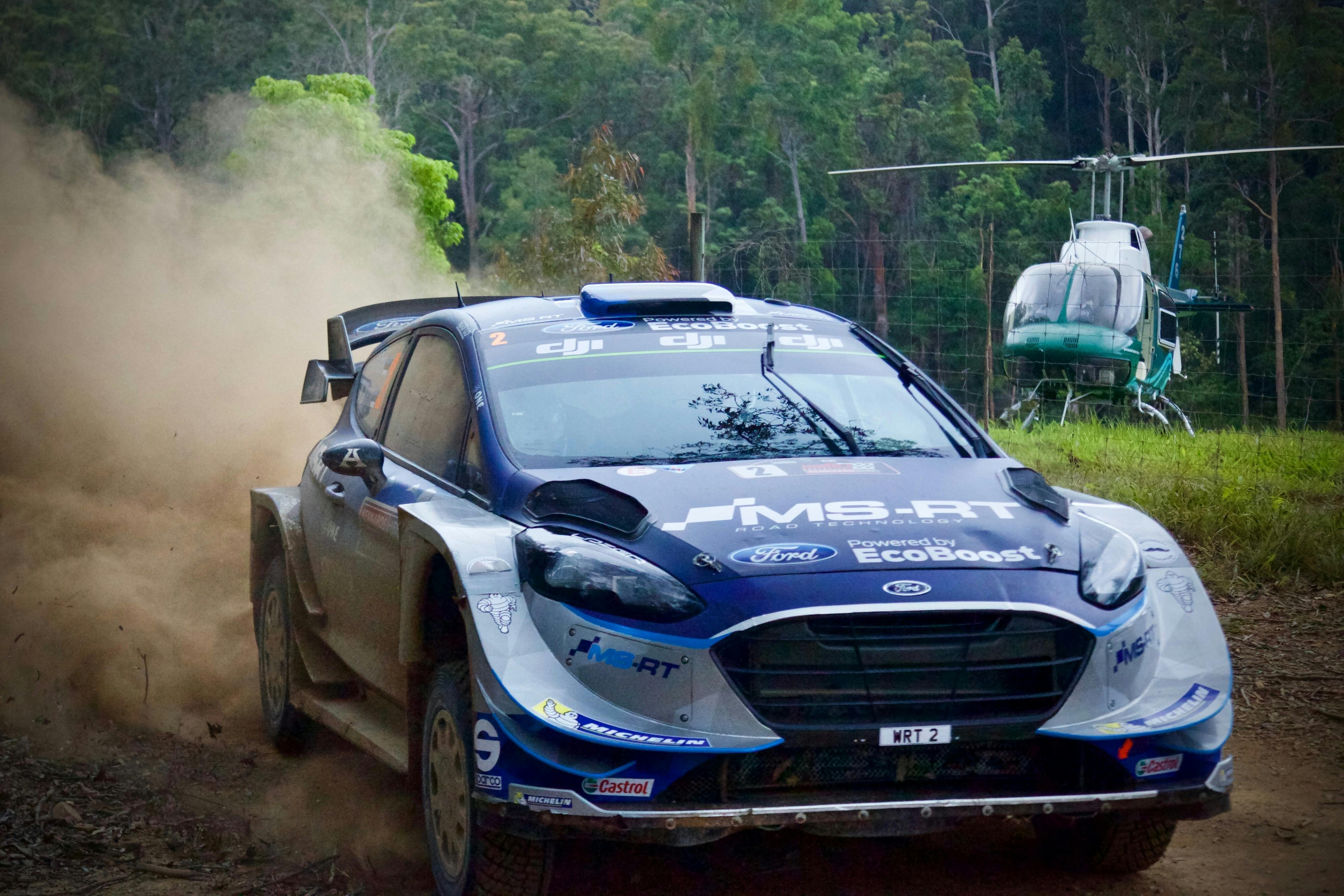 Rally car in the foreground with a Helicopter in the background