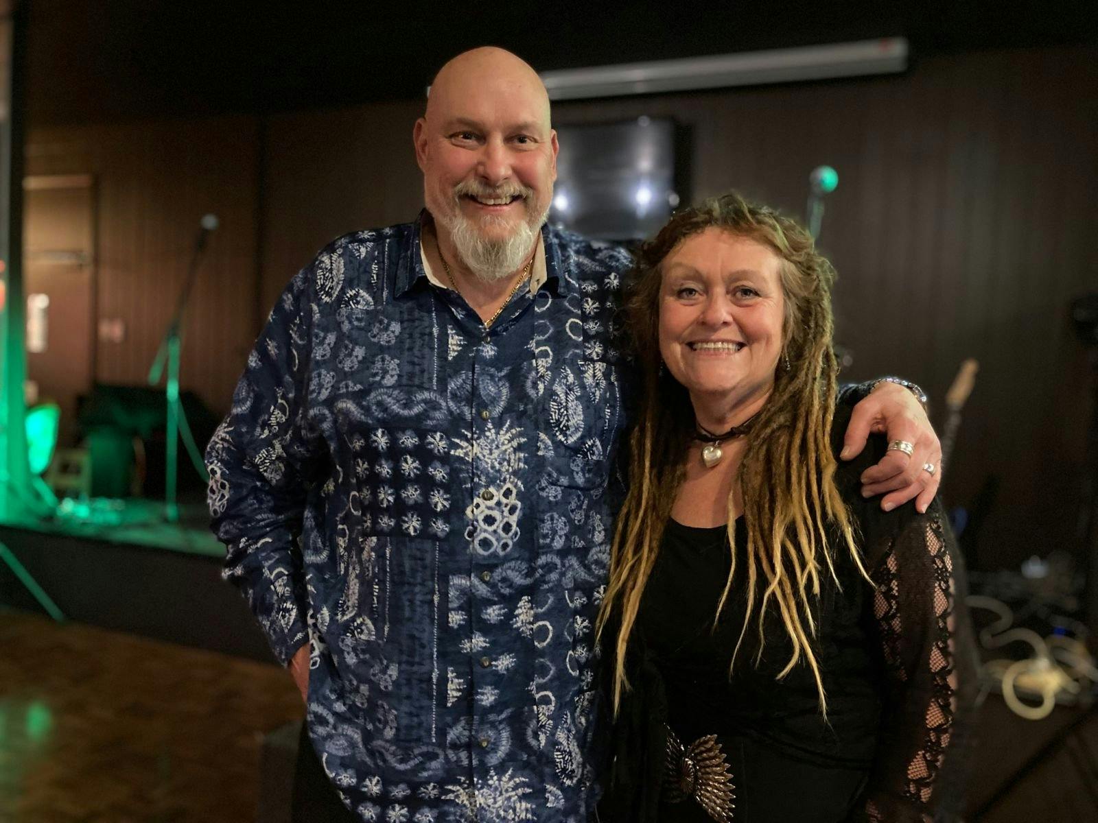 Man and Woman smiling for camera in front of stage