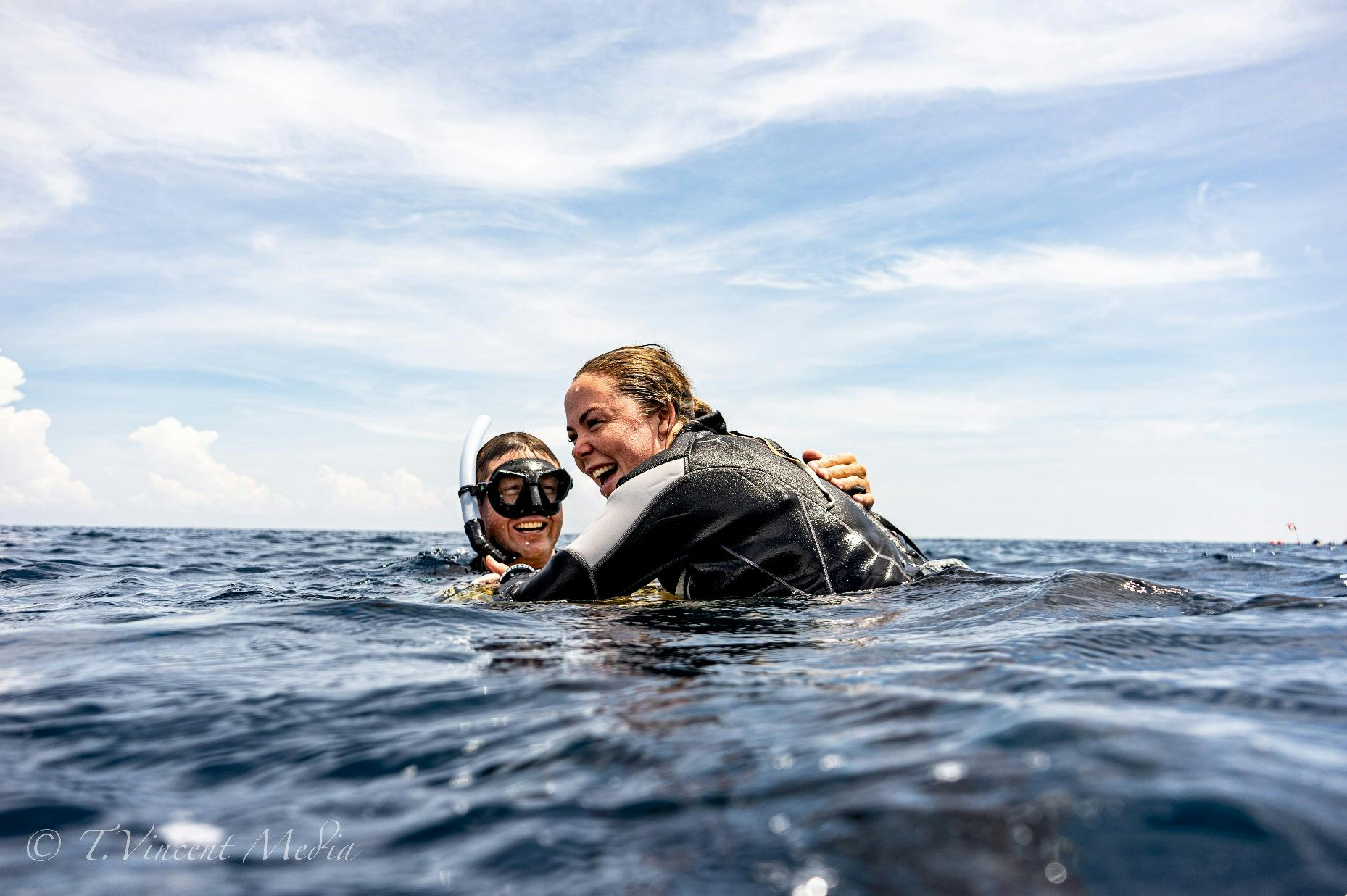 An instructor and freediving resting at the safety buoy after the diver came up from the line