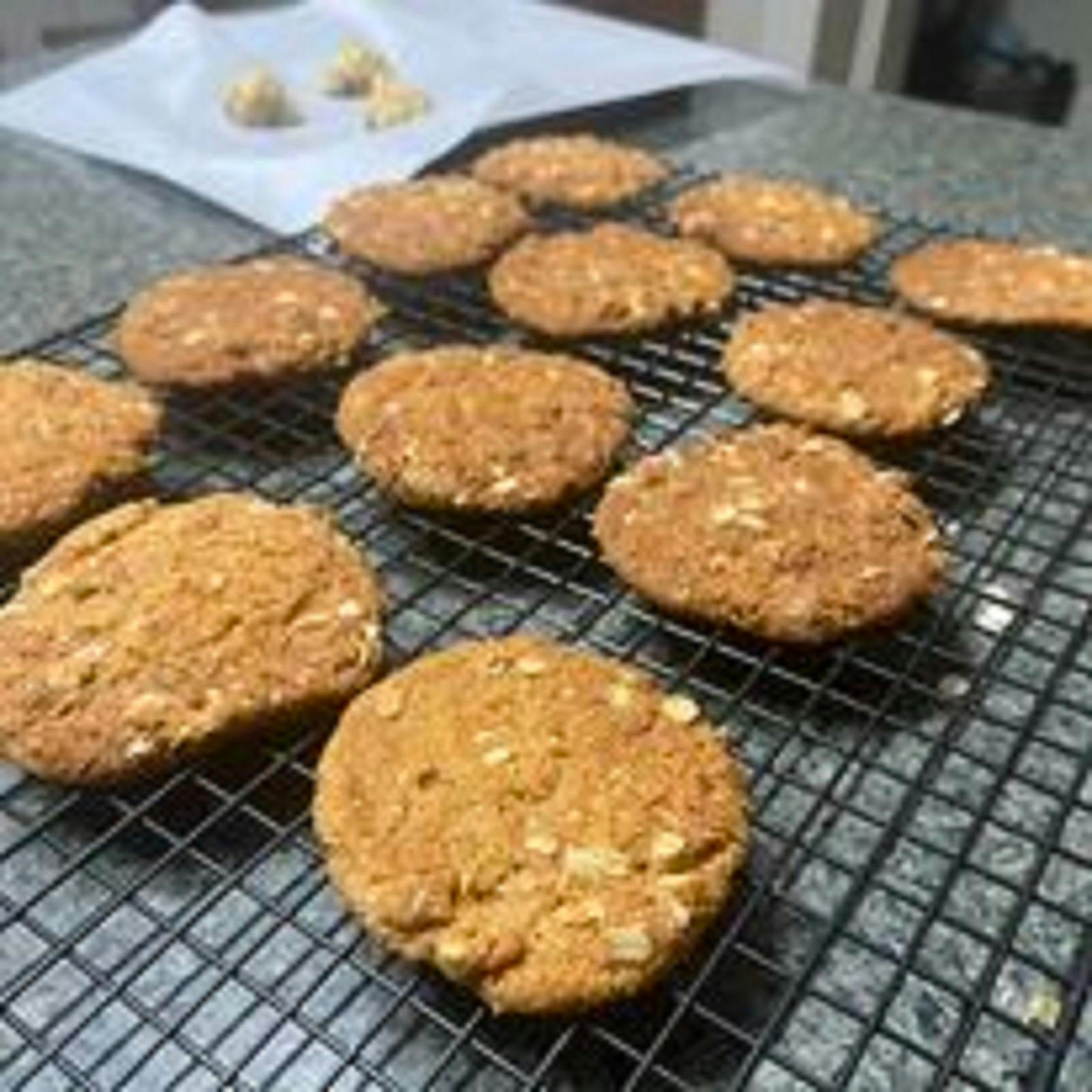 A rack full of delicious looking Anzac biscuits, uniform in size. You can see the rolled oats.