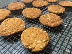 A rack full of delicious looking Anzac biscuits, uniform in size. You can see the rolled oats.