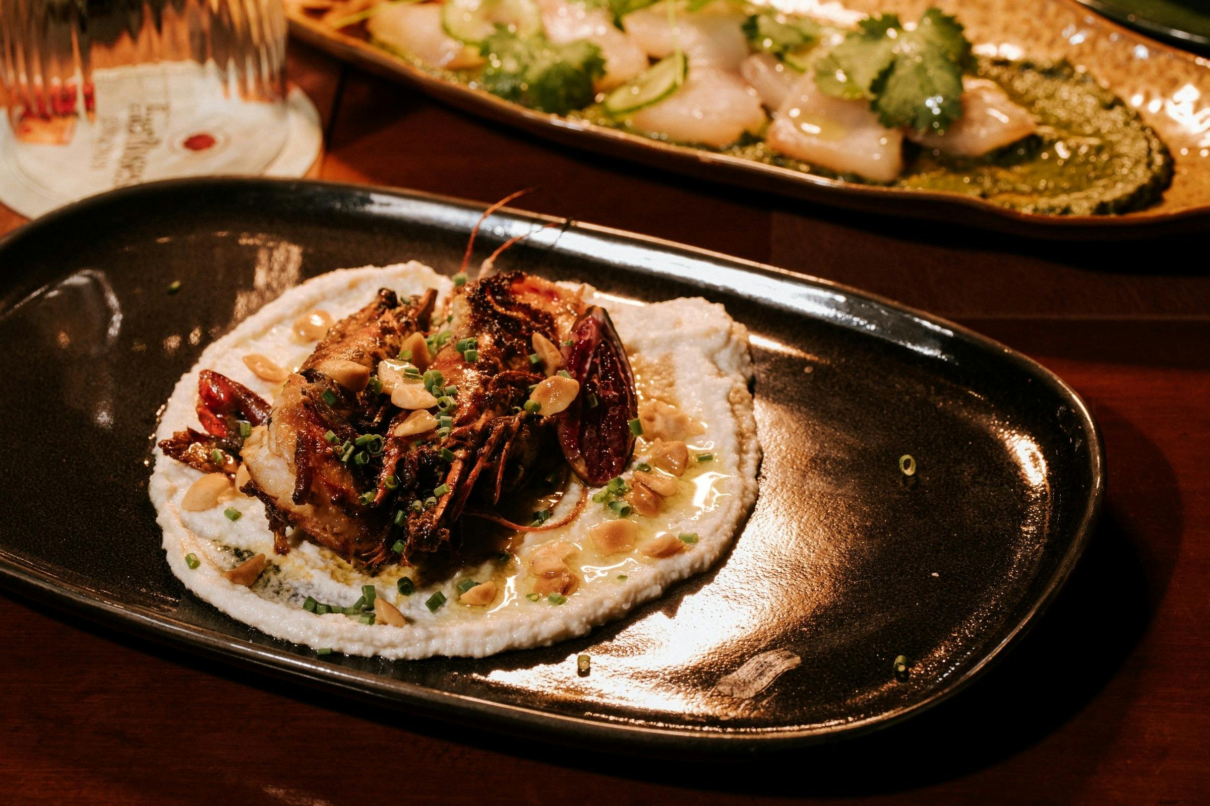 Close-up of a plated meat dish garnished with native greens