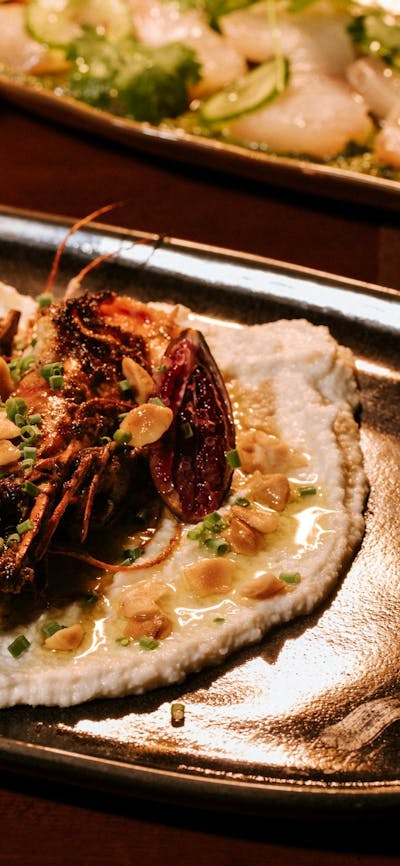Close-up of a plated meat dish garnished with native greens