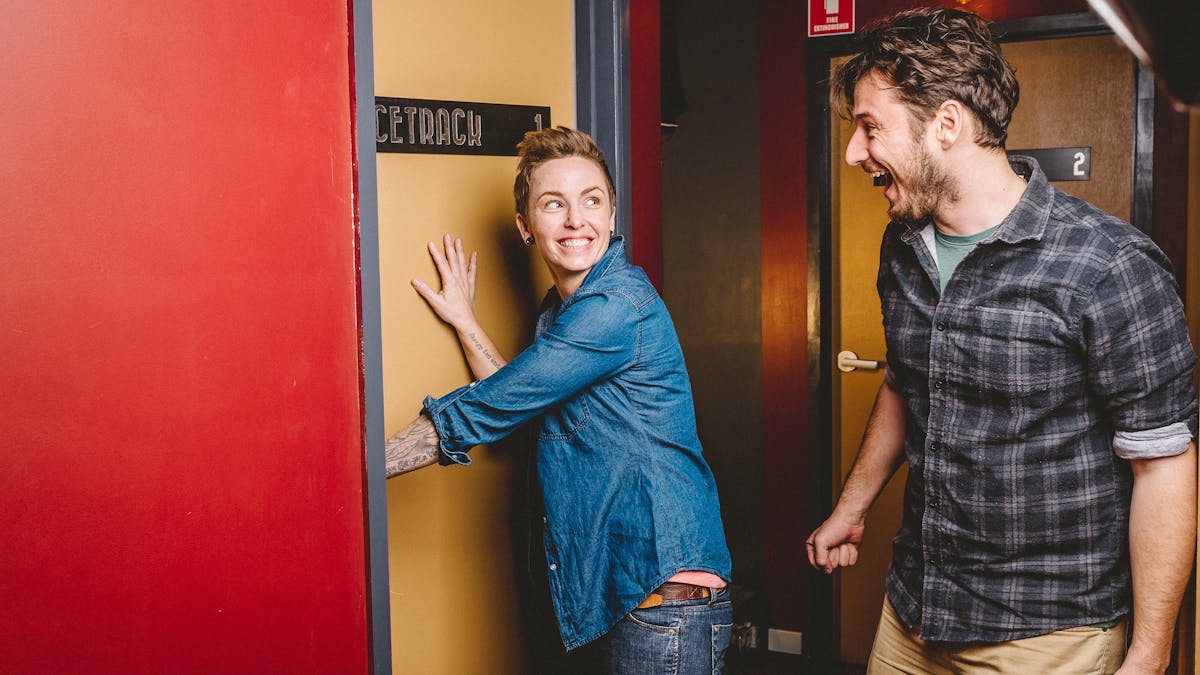2 people expectantly opening the door and entering an escape room