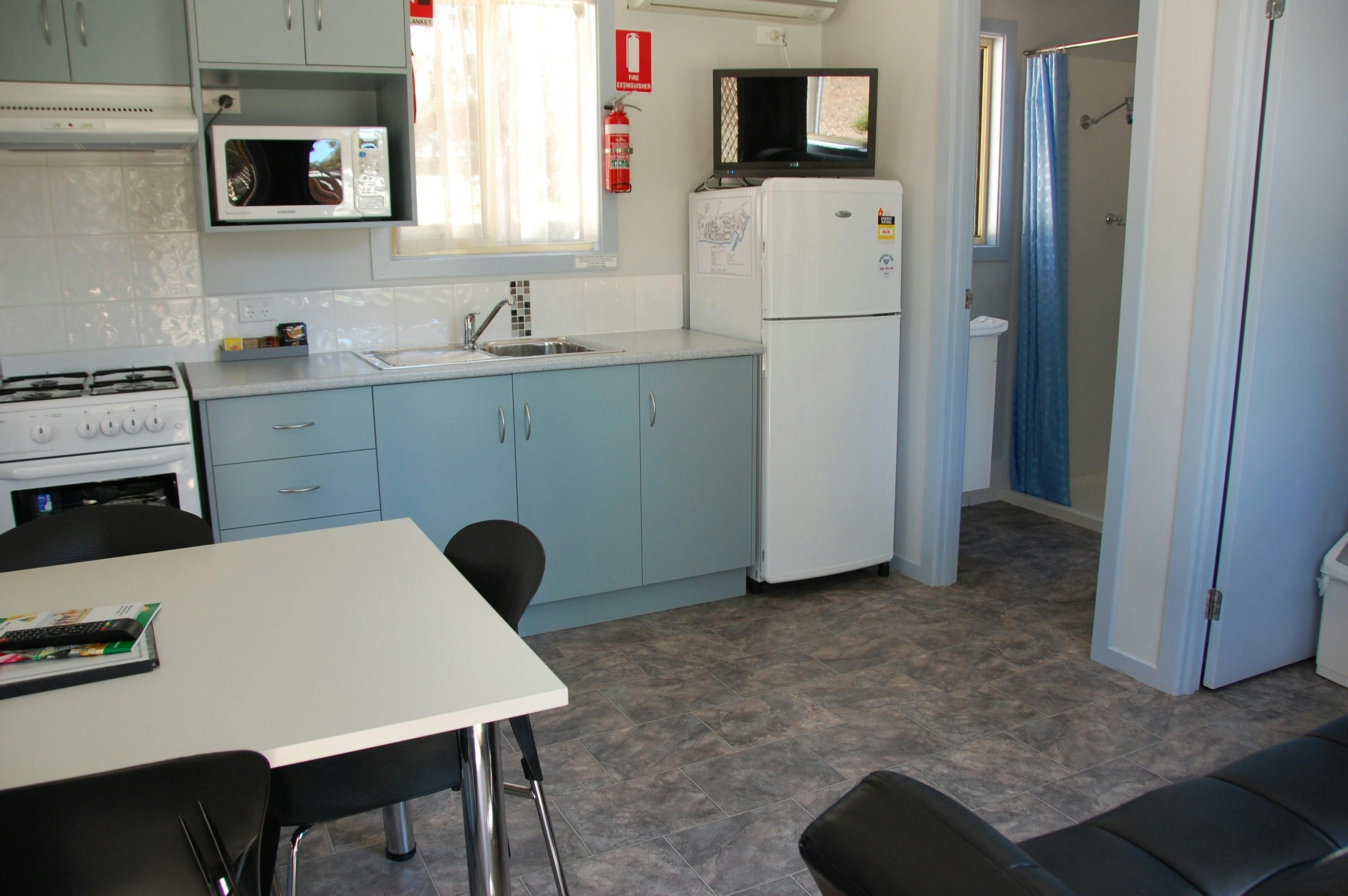 Kitchen with fridge, microwave, oven, stovetop and cupboards