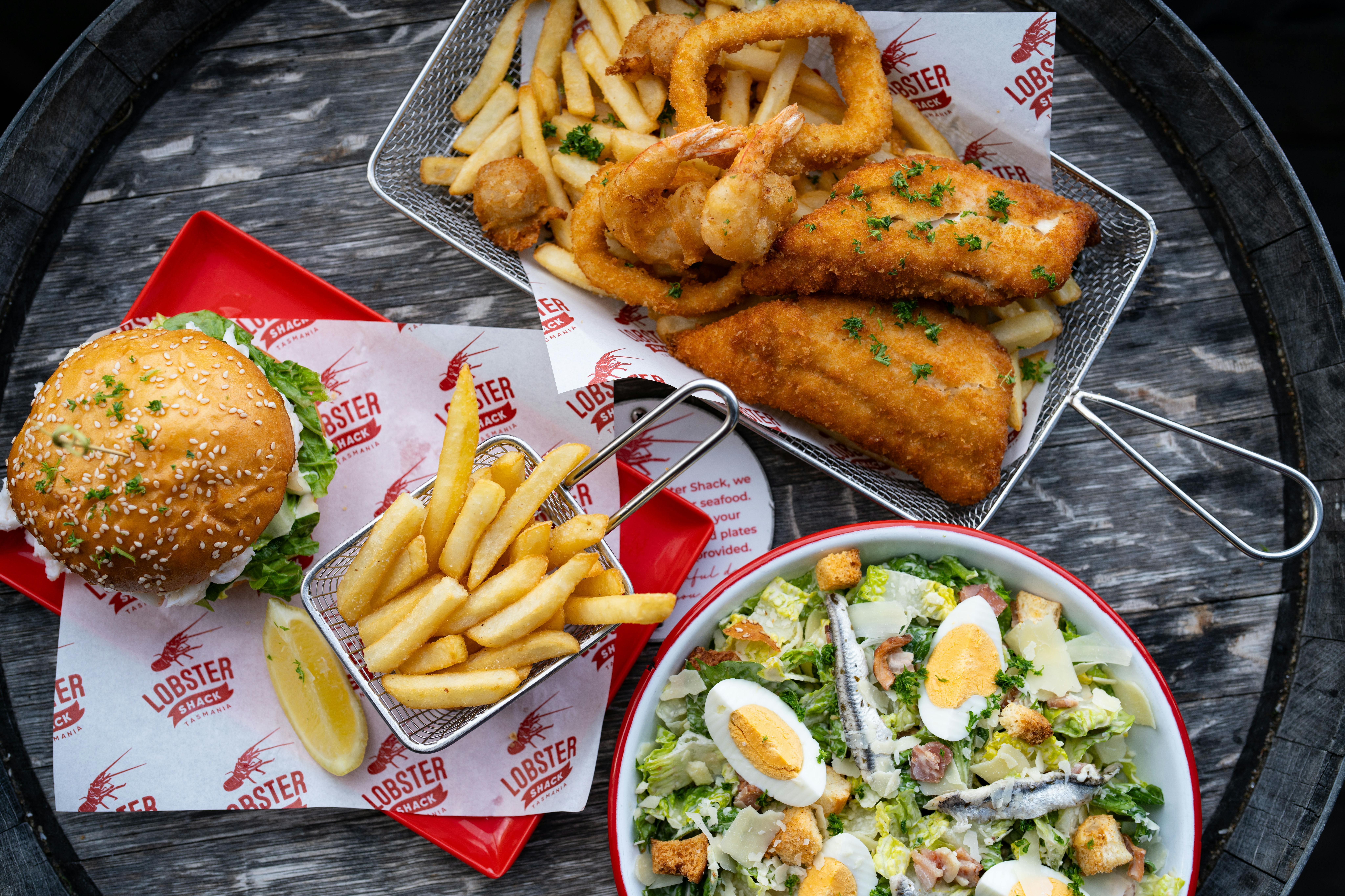 Photo of Lobster Shack Tasmania's lobster roll and chips, crumbed fish and chips and a ceasar salad