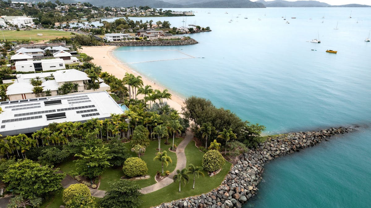 Aerial photo of park area, beach and houses and many boats in the water