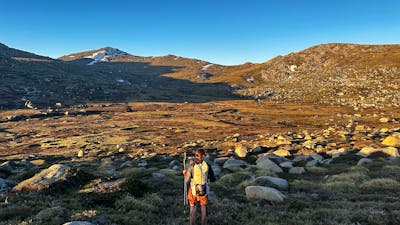 A hiker looking out into a valley in the mountains.