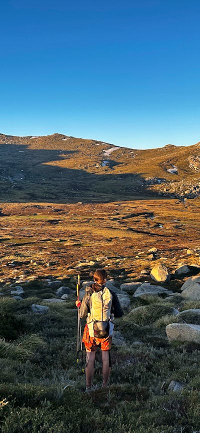 A hiker looking out into a valley in the mountains.