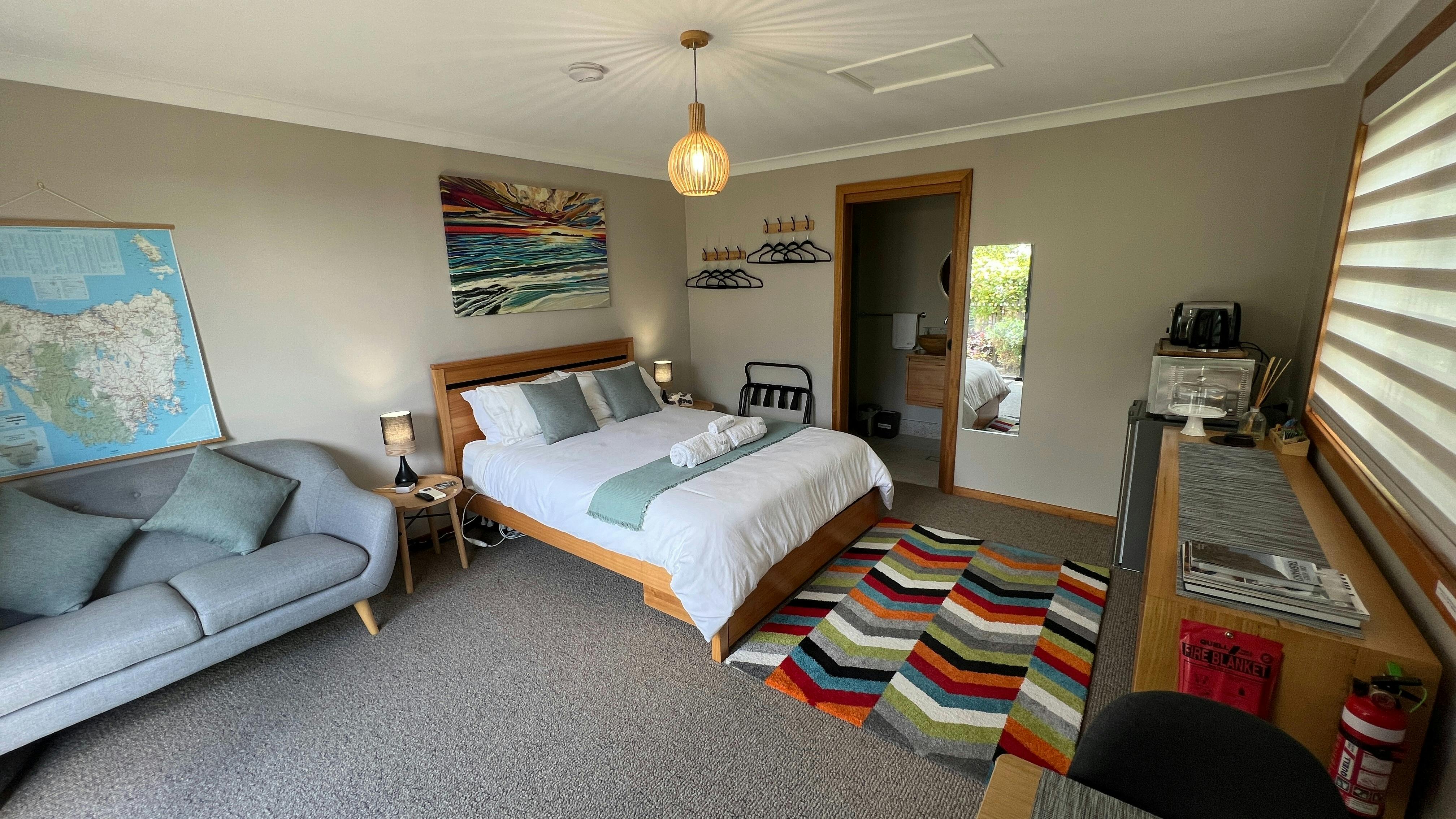 Queen bed, lounge, clothes hanging