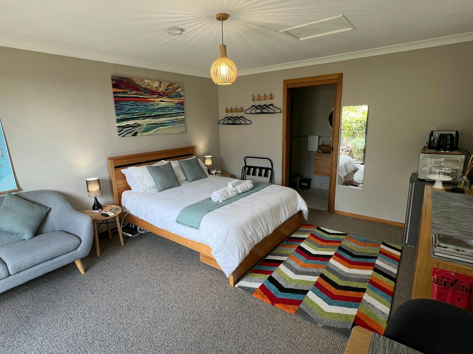 Queen bed, lounge, clothes hanging