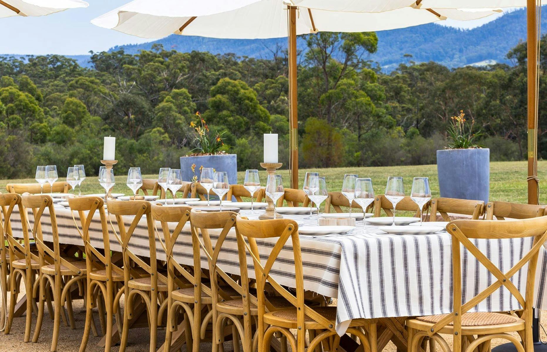 Image of outdoor dining setting at Saddle Ridge. There are umbrellas above the beautifully set table